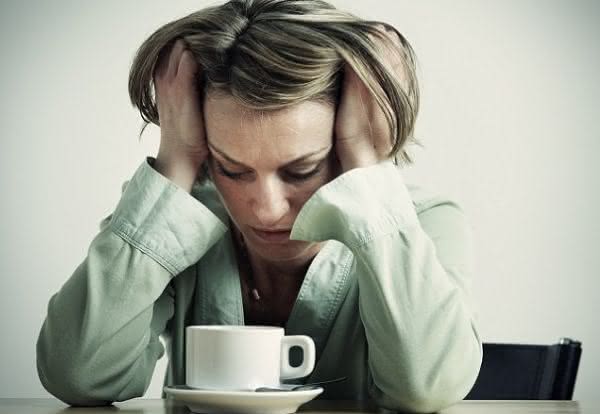 mulher com dor de cabeça vício em café